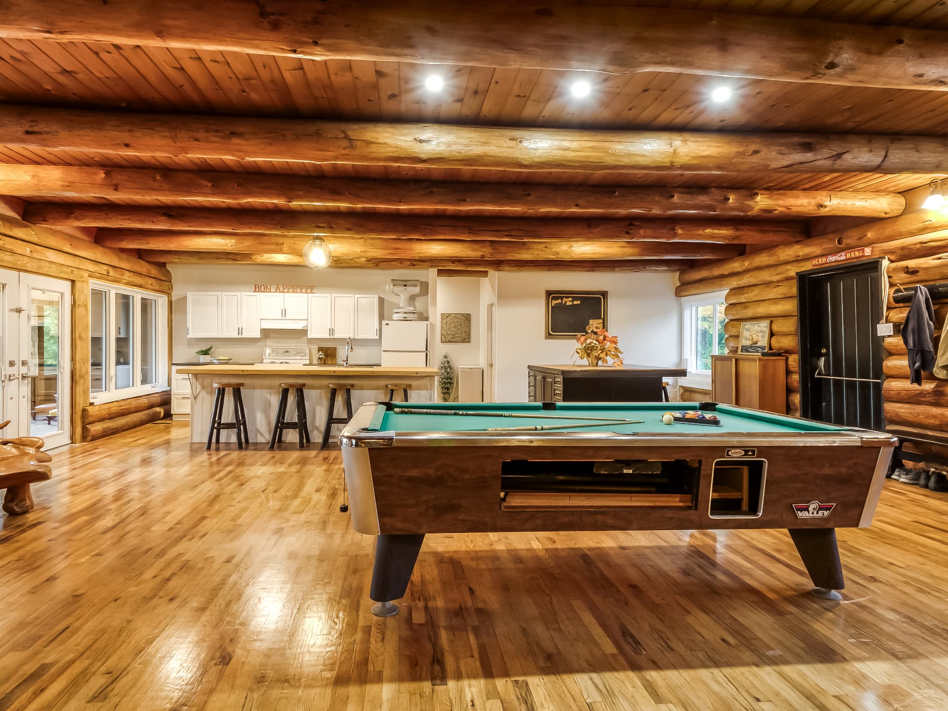 Pool table in the open living and kitchen space of the log home