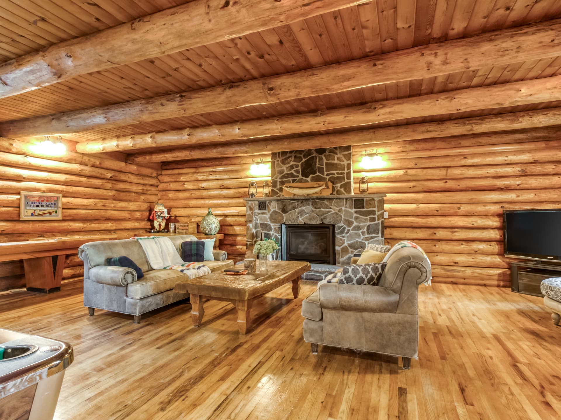 Log-home living room with a stone fireplace and seating