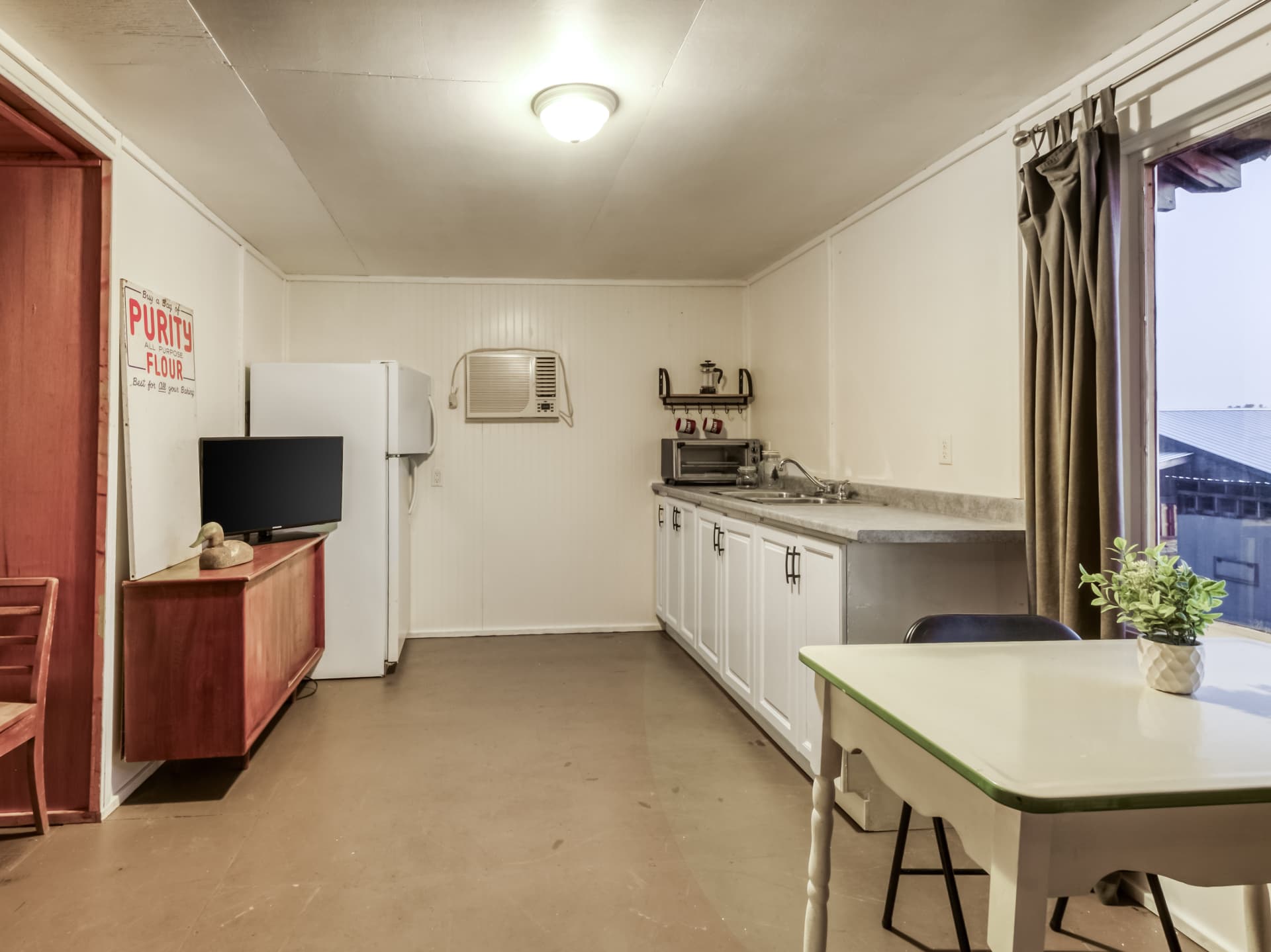 Cabin kitchenette with a refrigerator, counter, and dining table
