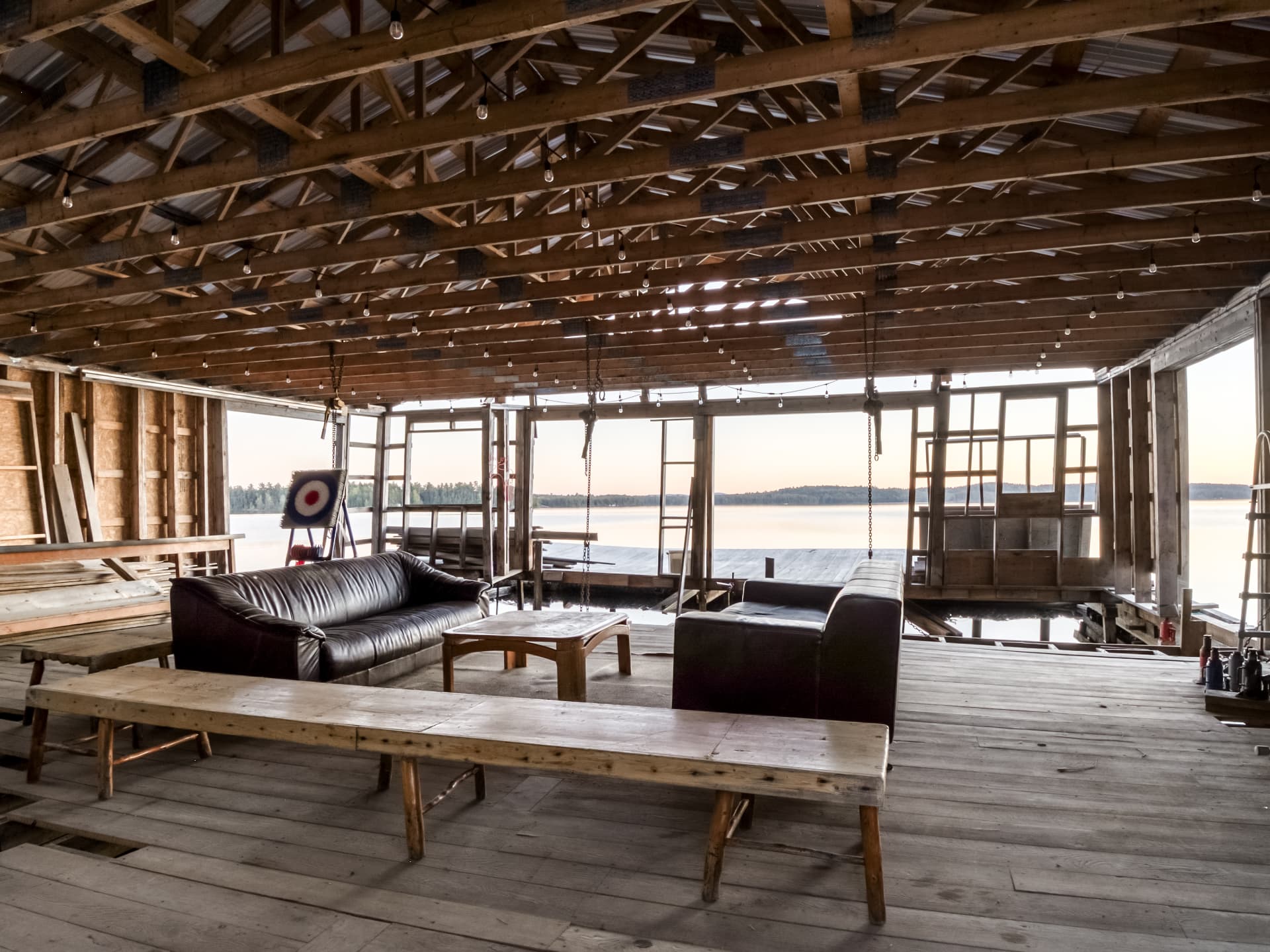 Interior of a large unfinished boathouse structure opening to Lake Panache