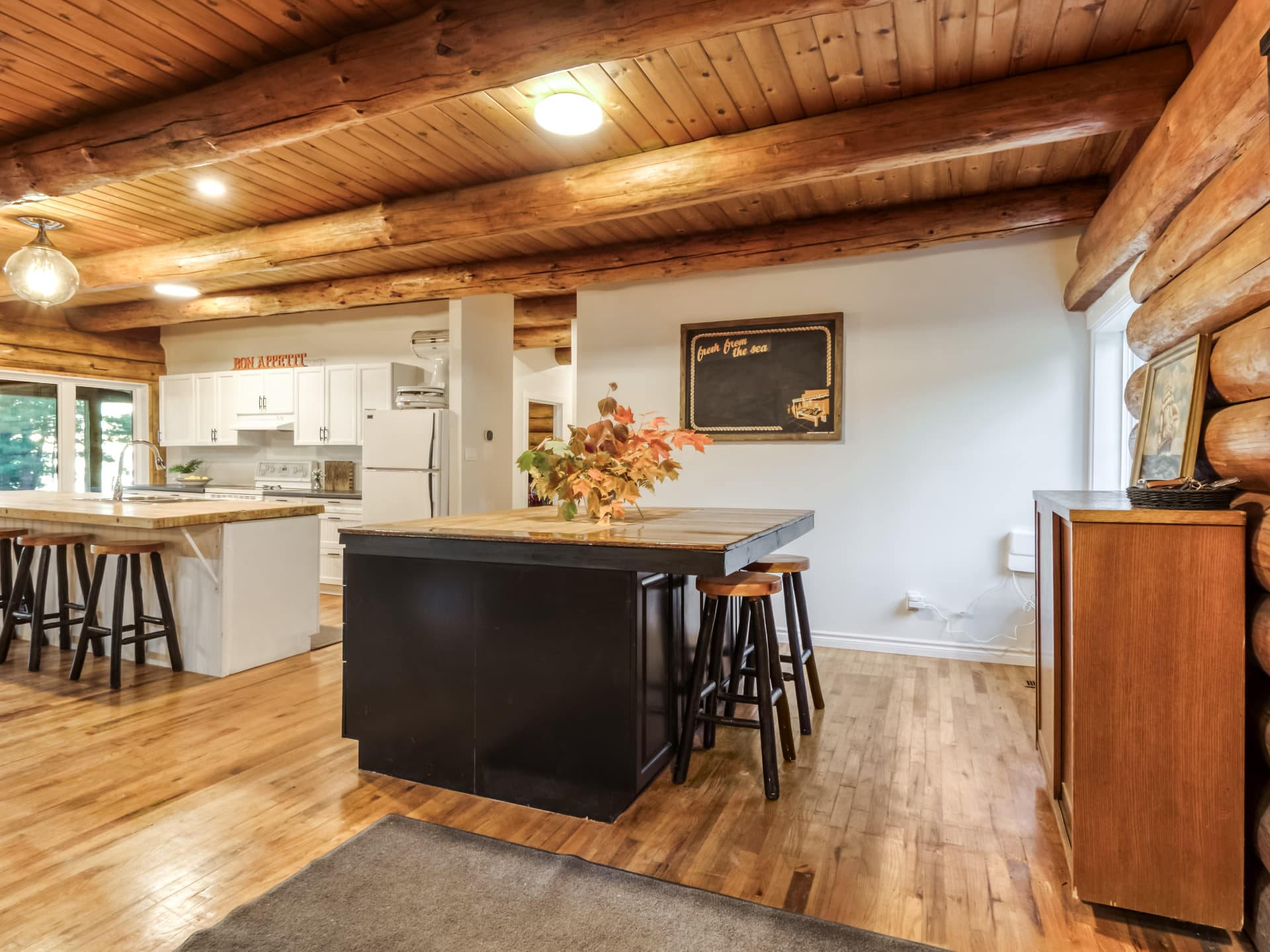 Log-home kitchen island with the living area beyond