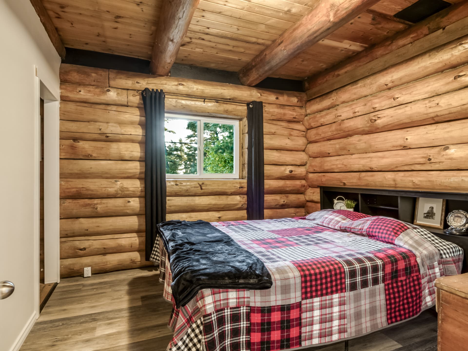 Bedroom in the log home with log walls and a bed