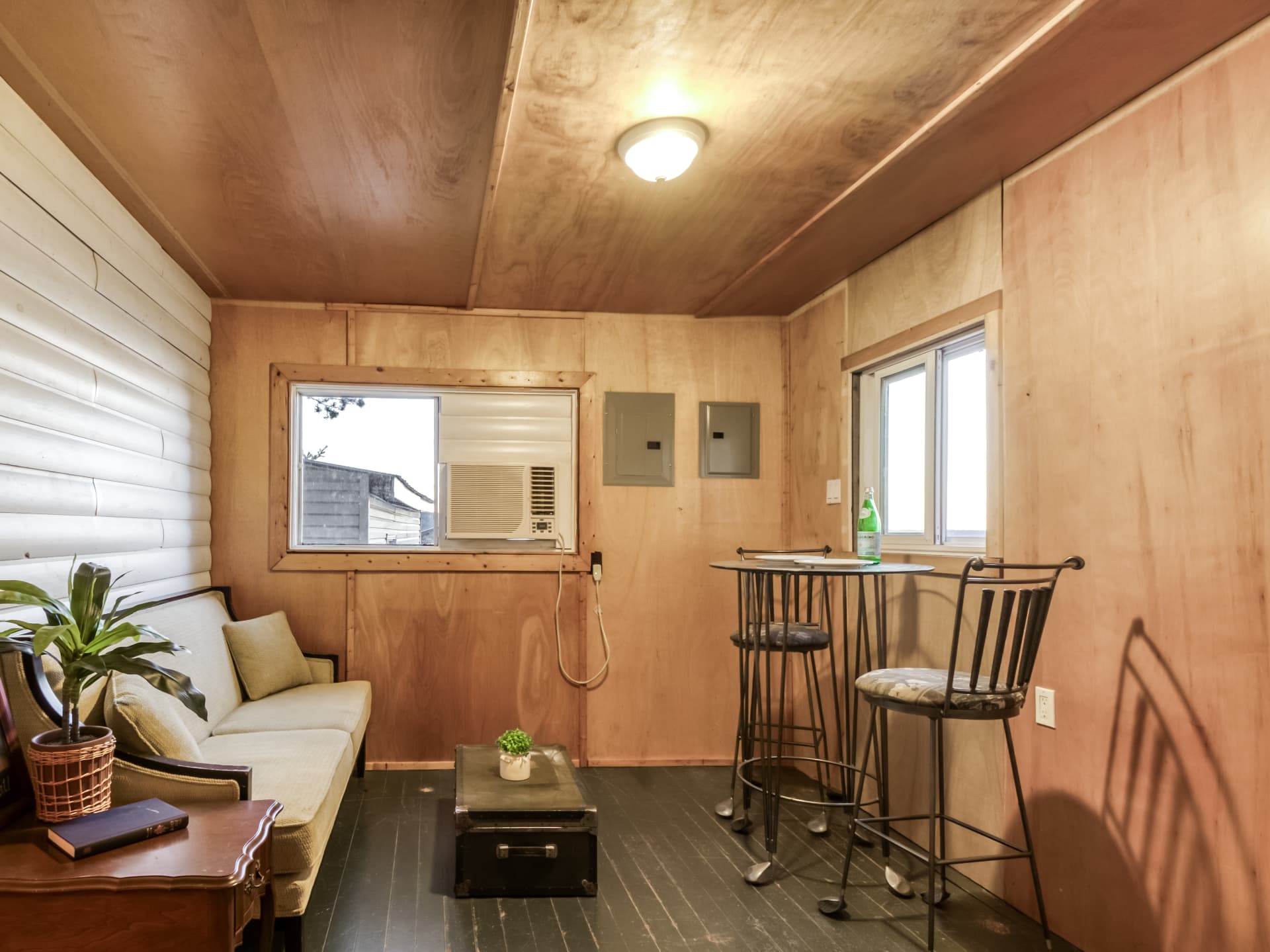 Sitting area with a high-top table inside a wood-panelled sleep cabin