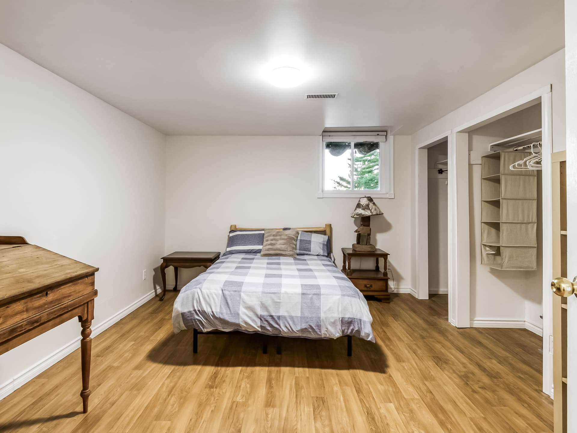 Lower-level bedroom with a bed, dresser, and closet