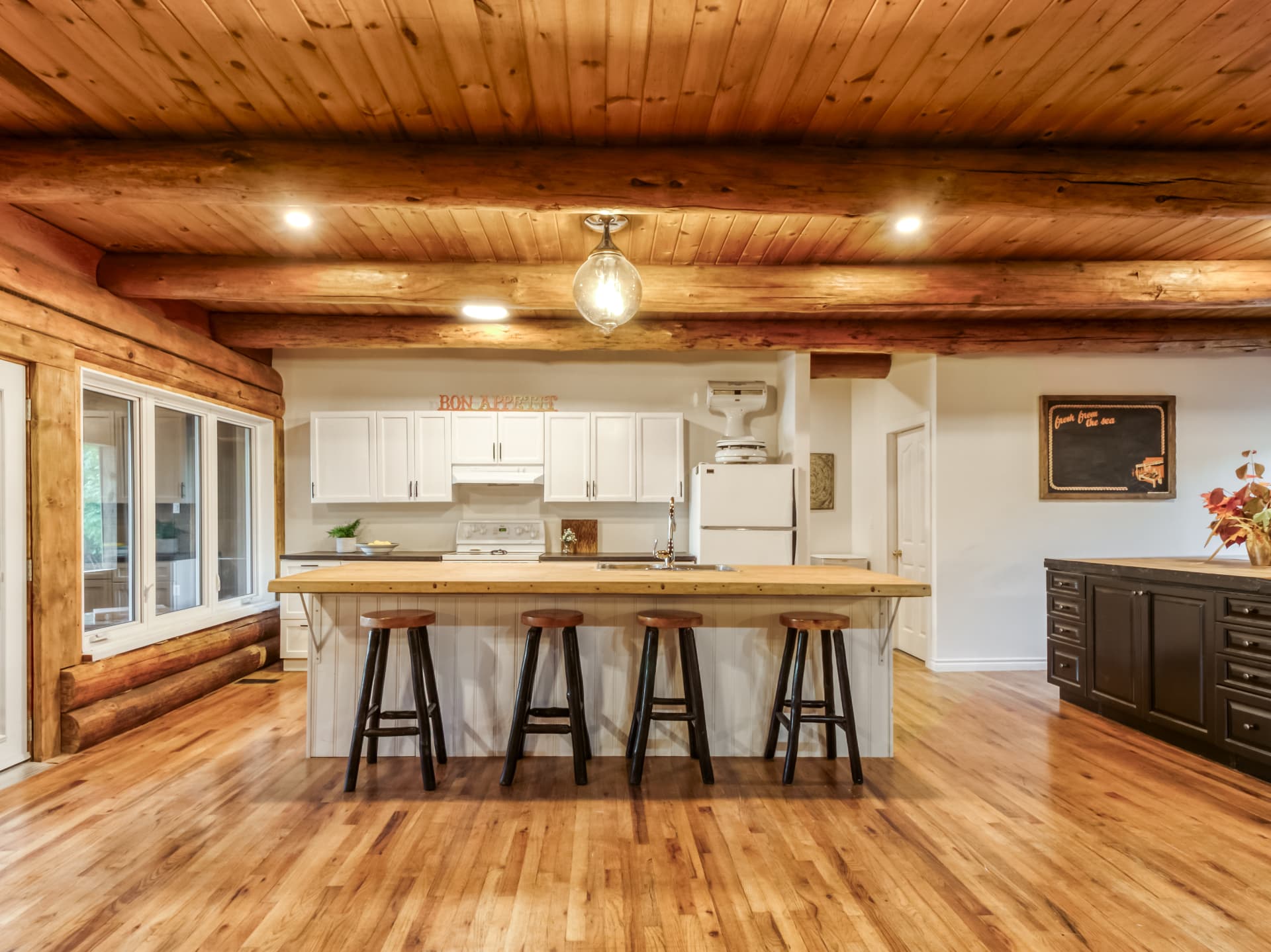 Wide view of the log-home kitchen and pool-table area