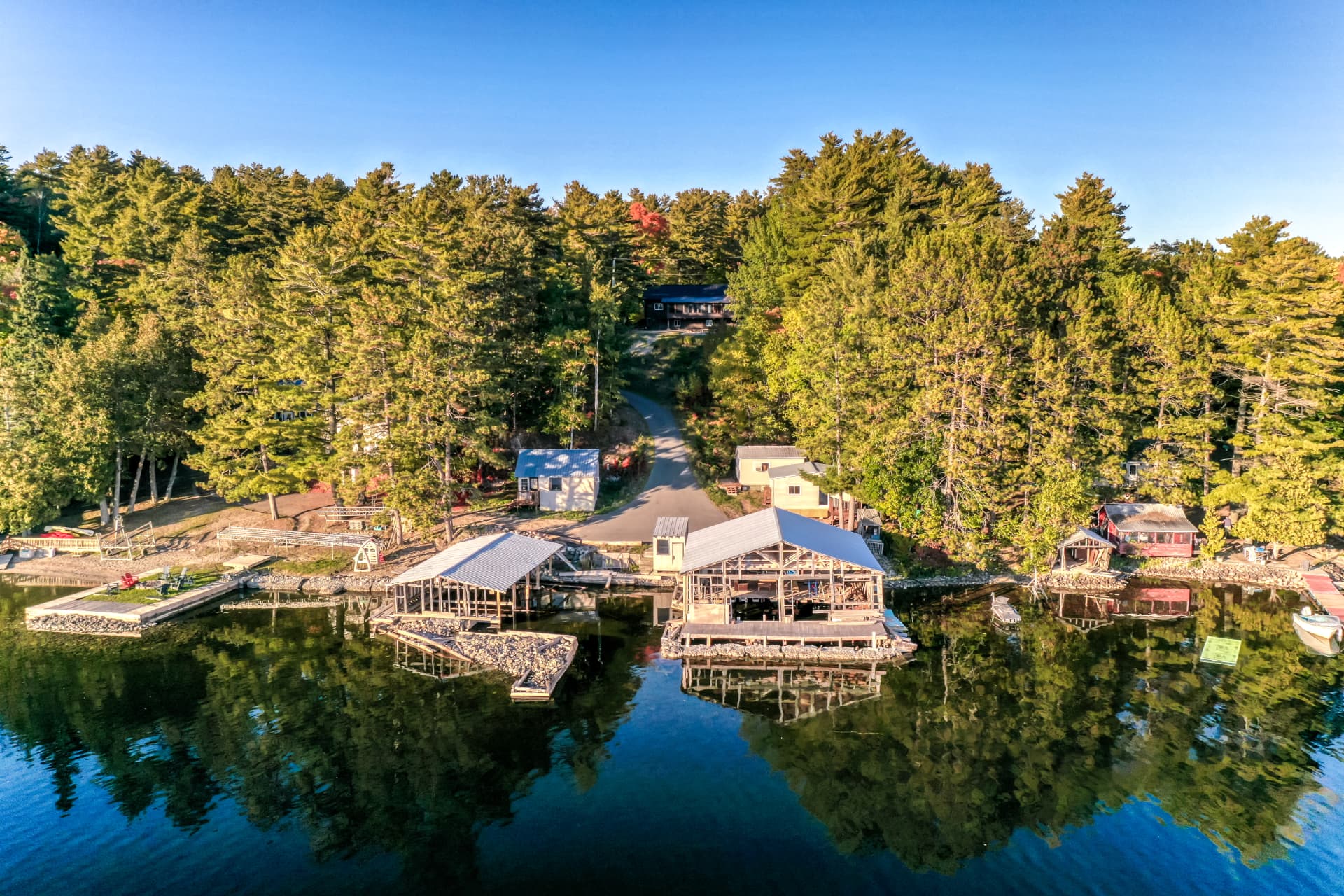 Aerial view of the Lake Panache shoreline, the road, trees, and the waterfront structures at 103A North Shore Road
