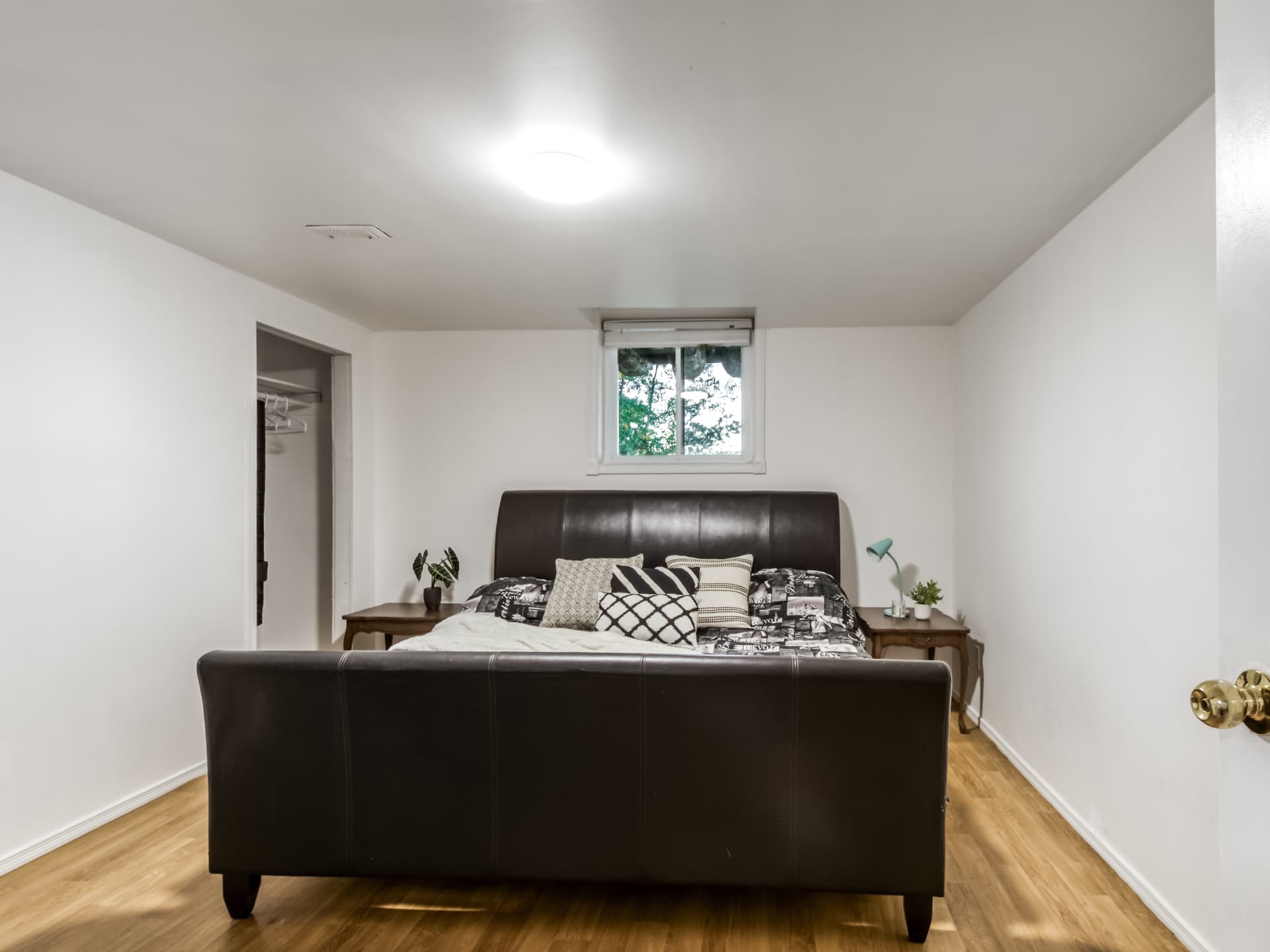 Lower-level bedroom with a large bed and closet
